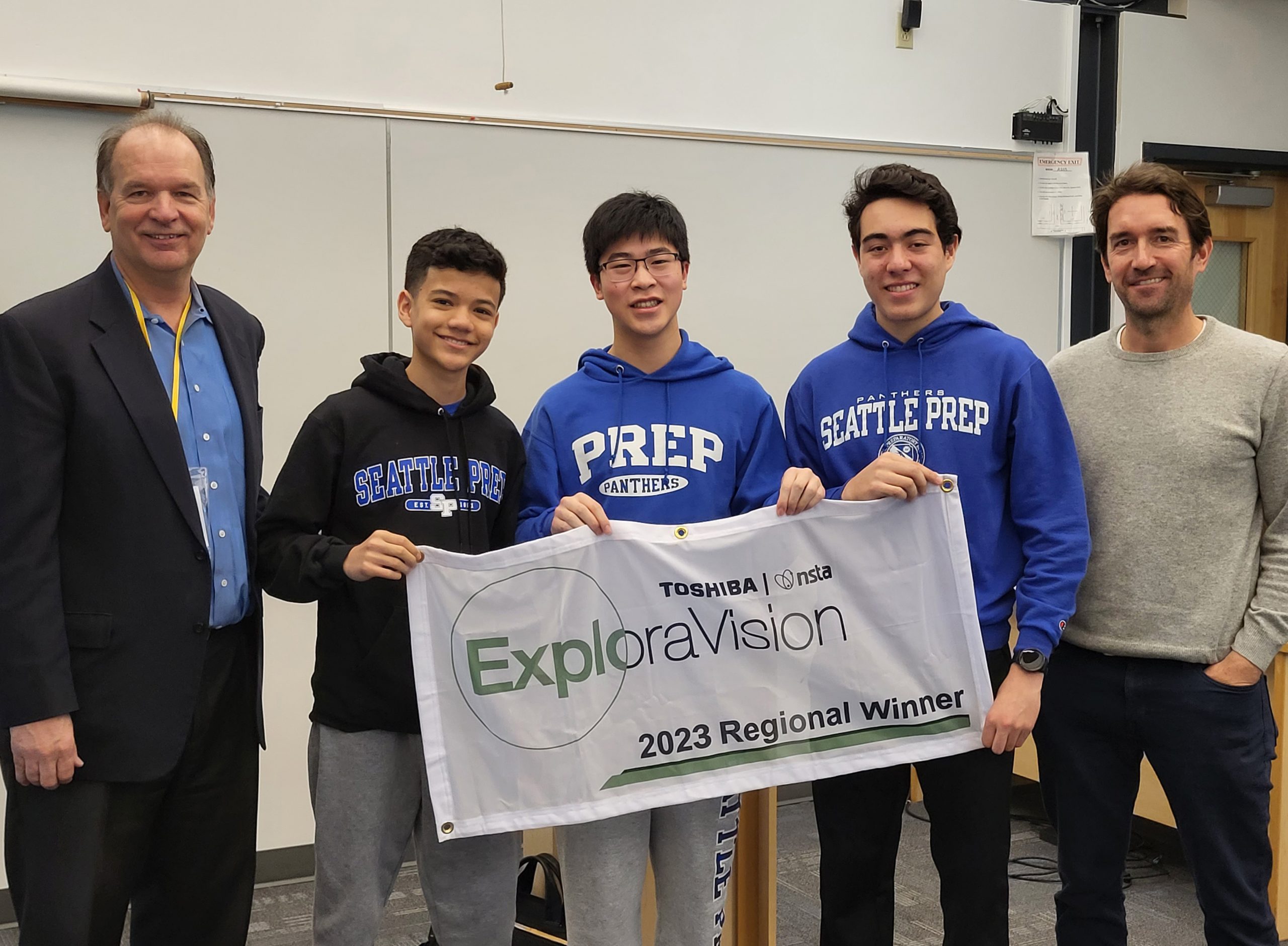 Jace and the Seattle Prep ExploraVision team holding the 2023 regional winner banner.